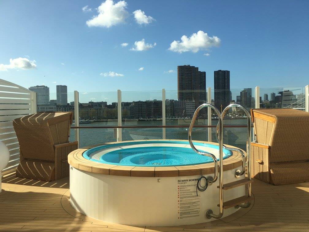 Außen-Whirpool mit Blick auf die Skyline, daneben stehen zwei Strandkörbe
