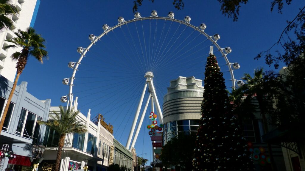 Blick auf ein Riesenrad in Las Vegas, in der Straße davor steht ein großer Weihnachtsbaum
