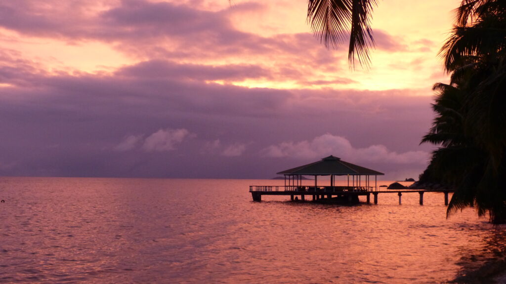 atemberaubender Sonnenuntergang mit Blick aufs Meer und einem Steg vom Hotel Coco de Mer