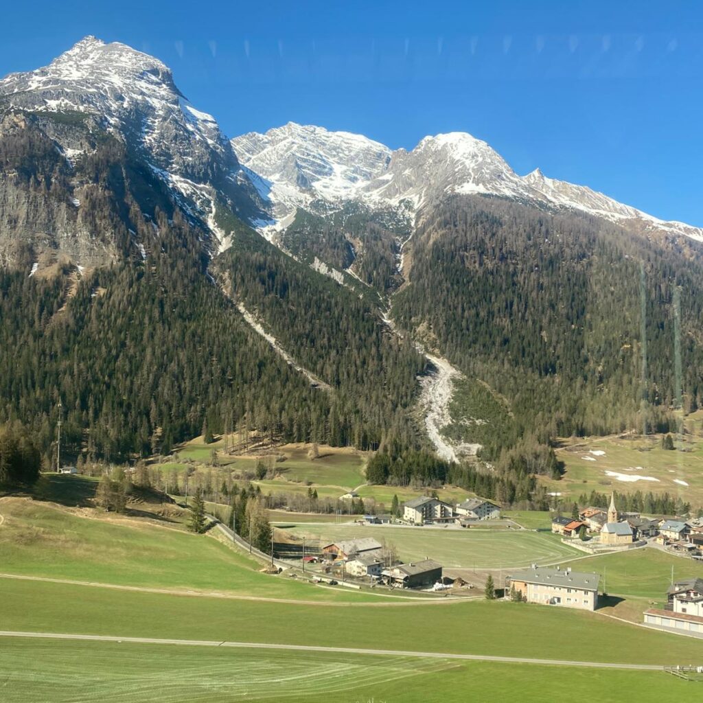 Ausblick aus dem Zug auf die schneedeckten Berge