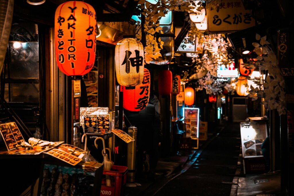 Kleine Geschäftsgasse bei Nacht mit traditionellen Laternen