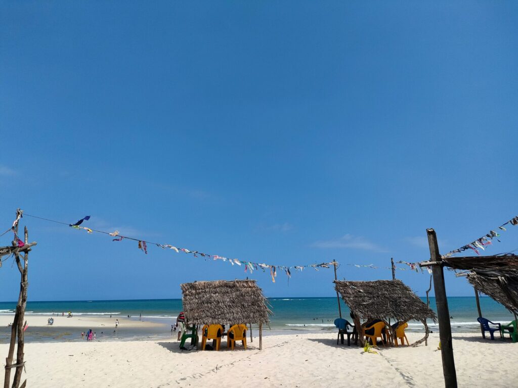 weißer Sandstrand mit überdachten Sitzecken